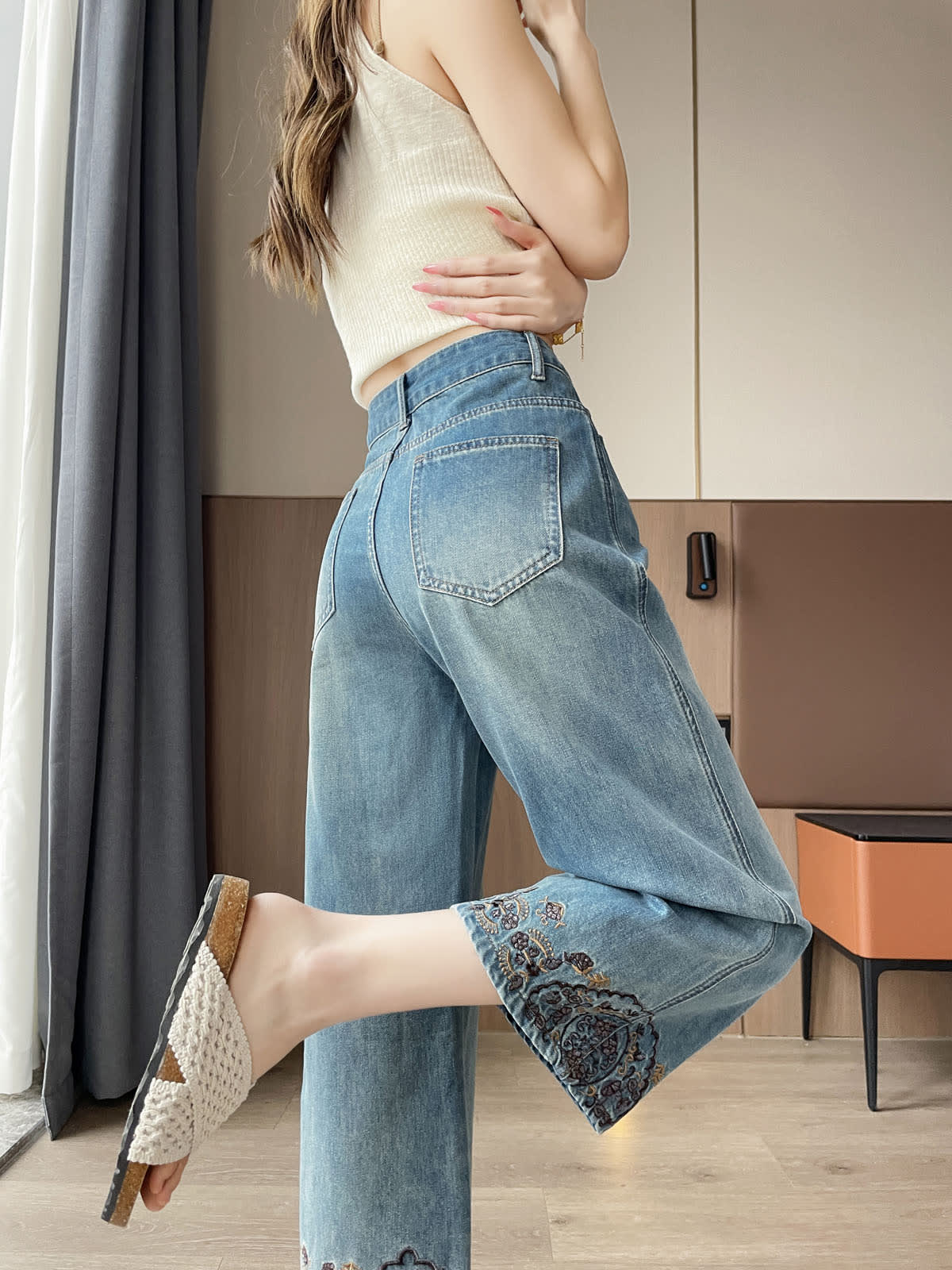 YEEYEEWang Straight Jeans in Vintage Blue, Asian-fit cut, waist-down back view with back patch pockets, one leg raised showing embroidered hem.