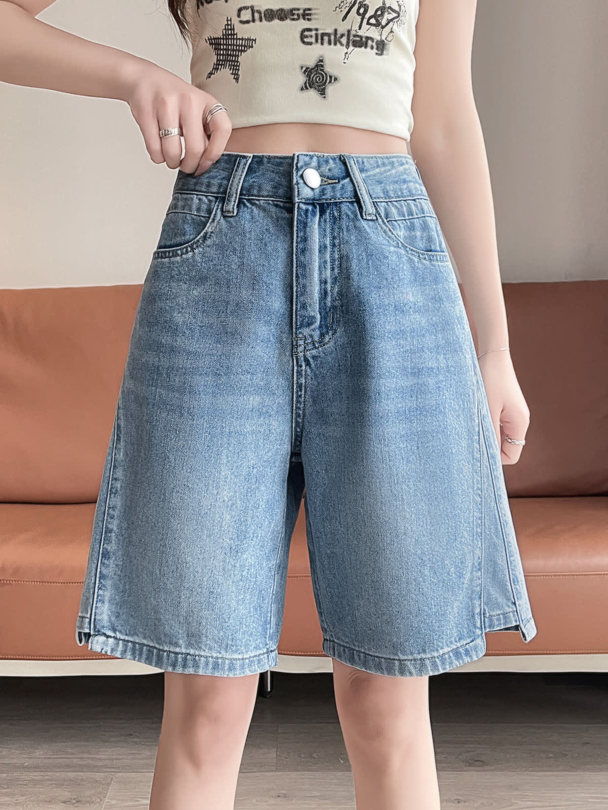 YEEYEEWang Denim Bermuda Shorts in Blue, Asian-fit cut, waist-down front view with hand adjusting the waistband, variant thumbnail.
