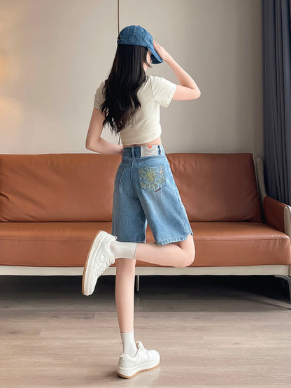 YEEYEEWang Denim Bermuda Shorts in Blue, Asian-fit cut, full-body back three-quarter leg-kick pose, hand touching the cap brim, embroidered back patch pocket visible.