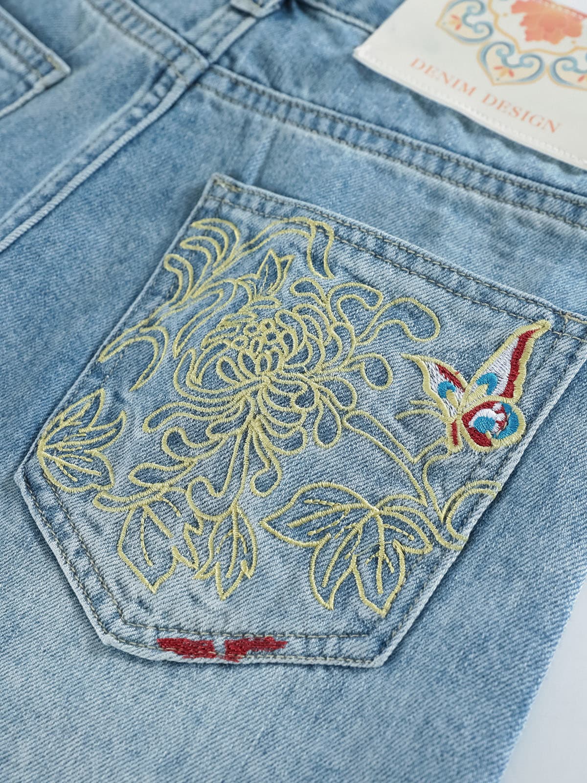 YEEYEEWang Denim Bermuda Shorts in Blue, Asian-fit cut, close-up of the back patch pocket with delicate embroidery and clean edge stitching.