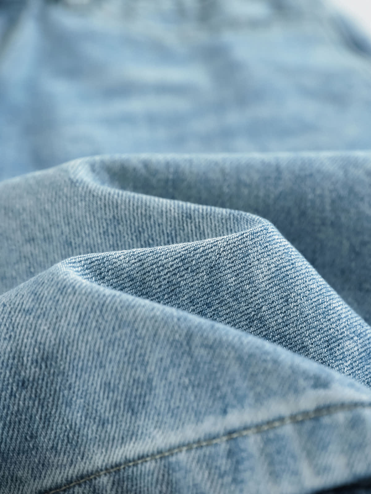 YEEYEEWang Denim Bermuda Shorts in Blue, Asian-fit cut, close-up of the washed denim fabric showing fine twill texture and soft hand feel.