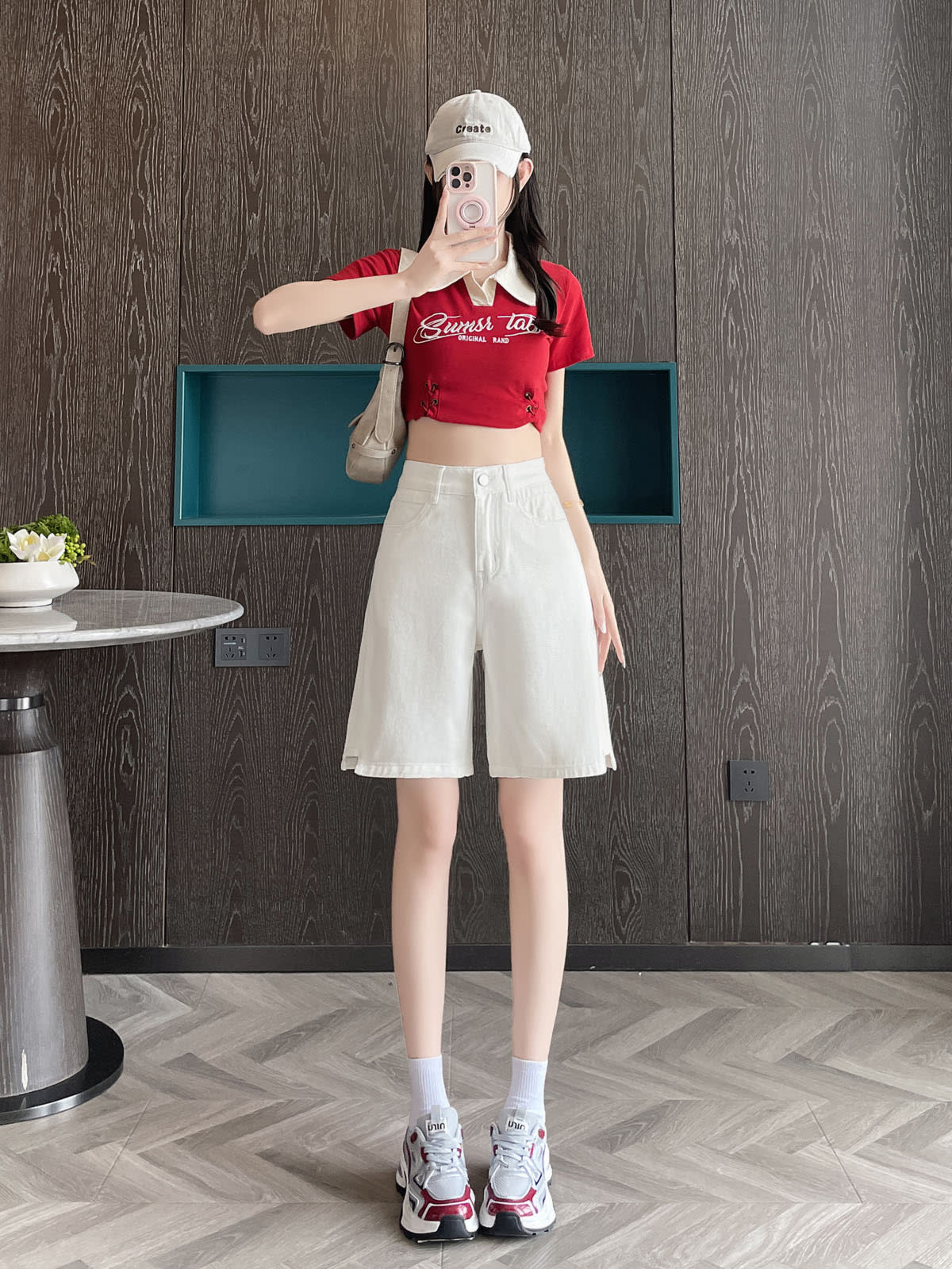 YEEYEEWang Denim Bermuda Shorts in White, Asian-fit cut, full-body front standing pose holding phone at face, styled with cap and shoulder bag.