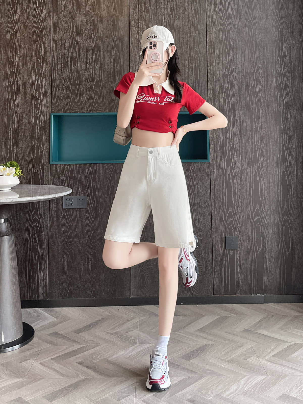 YEEYEEWang Denim Bermuda Shorts in White, Asian-fit cut, full-body front leg-kick pose holding phone at face, one hand resting on waistband.