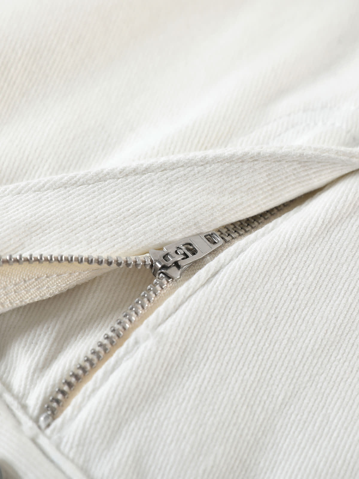 YEEYEEWang Denim Bermuda Shorts in White, Asian-fit cut, close-up of silver-tone zipper fly on fine twill denim.