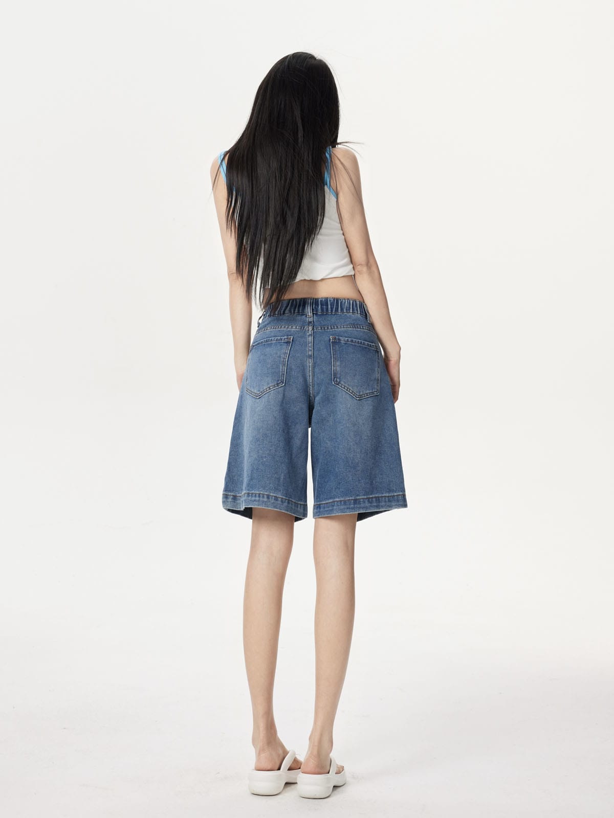 YEEYEEWang Denim Bermuda Shorts in Blue, Asian-fit cut, full-body back standing view showing back patch pockets and elastic-back waistband with white slides.