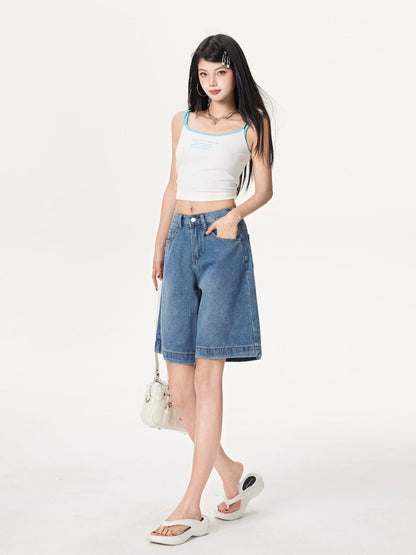 YEEYEEWang Denim Bermuda Shorts in Blue, Asian-fit cut, full-body three-quarter standing pose holding a white handbag at side, one hand in front pocket.
