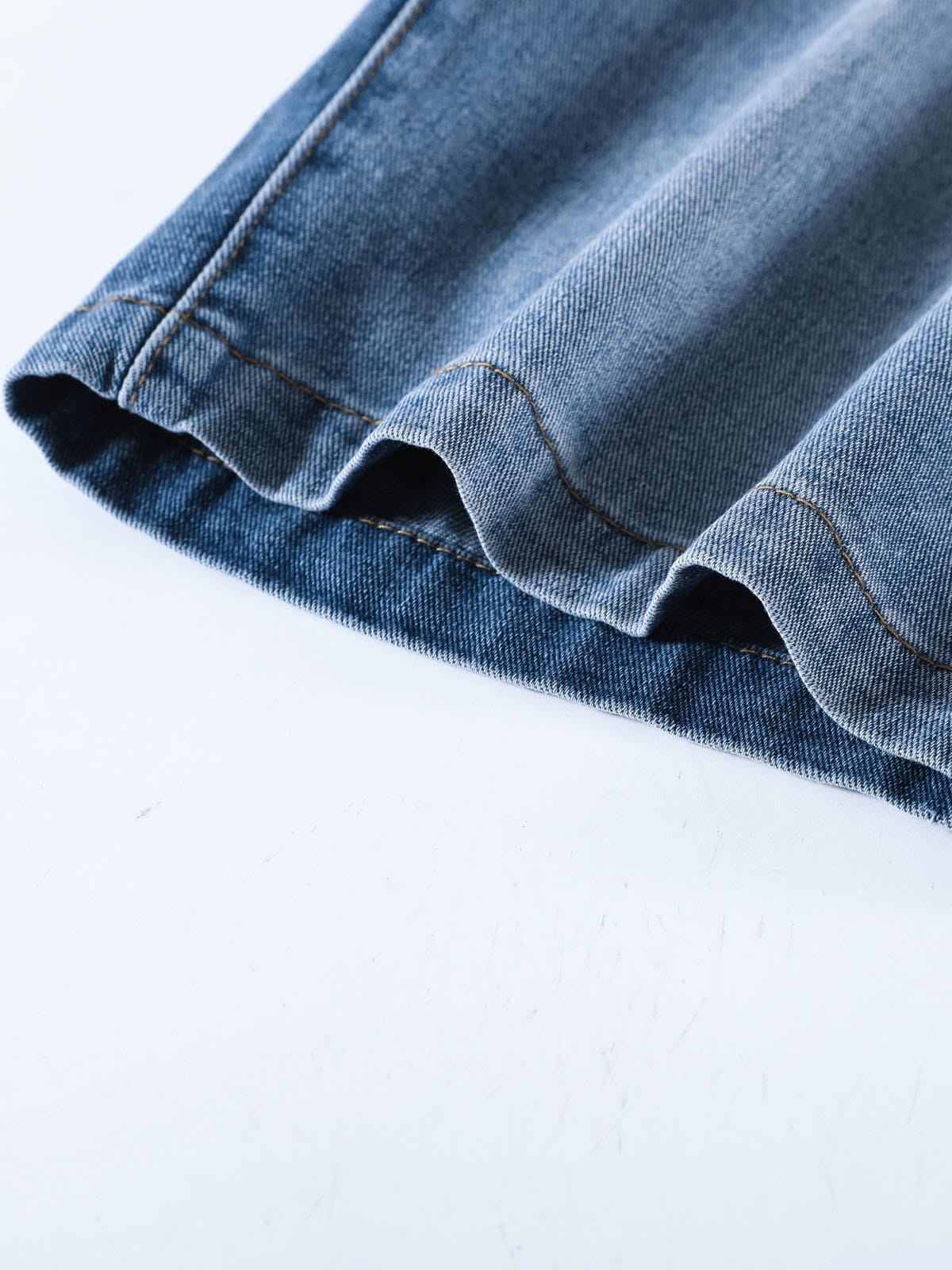 YEEYEEWang Denim Bermuda Shorts in Blue, Asian-fit cut, close-up of cuffed hem with contrast stitching and washed denim texture.