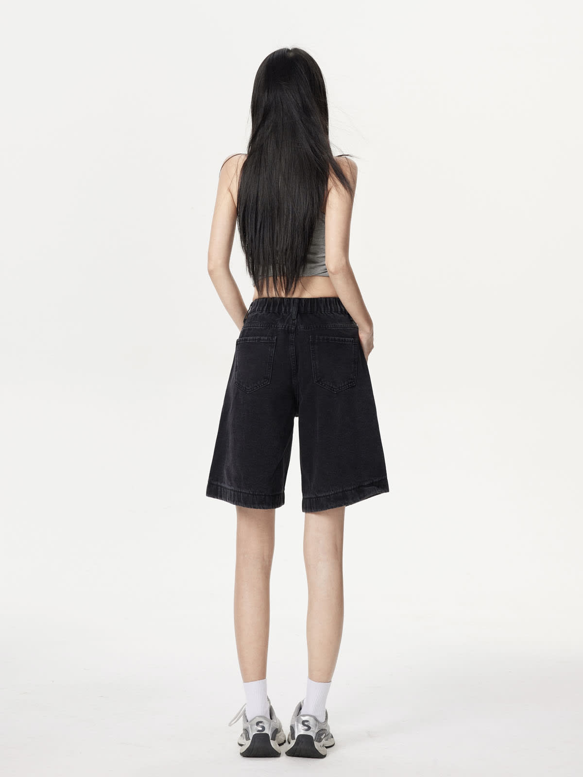 YEEYEEWang Denim Bermuda Shorts in Solid Black, Asian-fit cut, full-body back standing view showing back patch pockets and elastic-back waistband with sneakers.