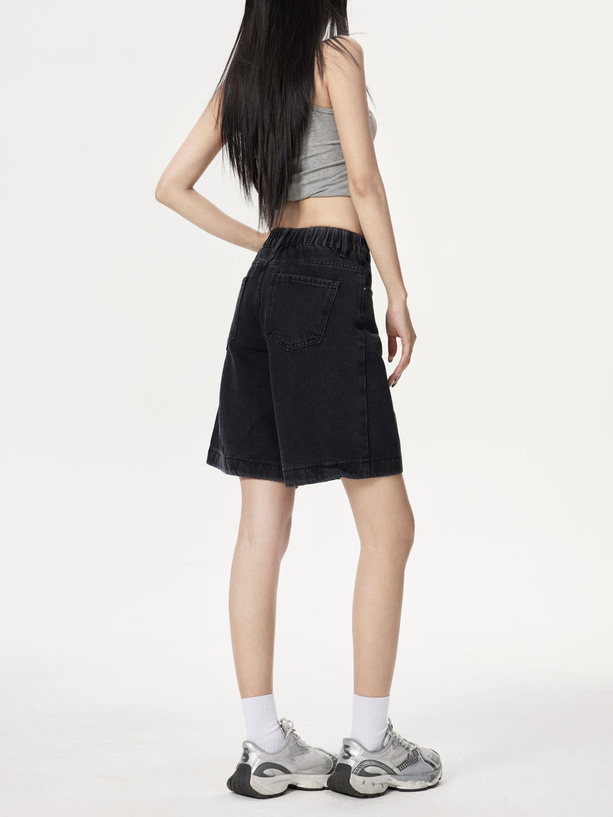 YEEYEEWang Denim Bermuda Shorts in Solid Black, Asian-fit cut, waist-down back-side view showing back patch pocket and gathered elastic-back waistband with sneakers.