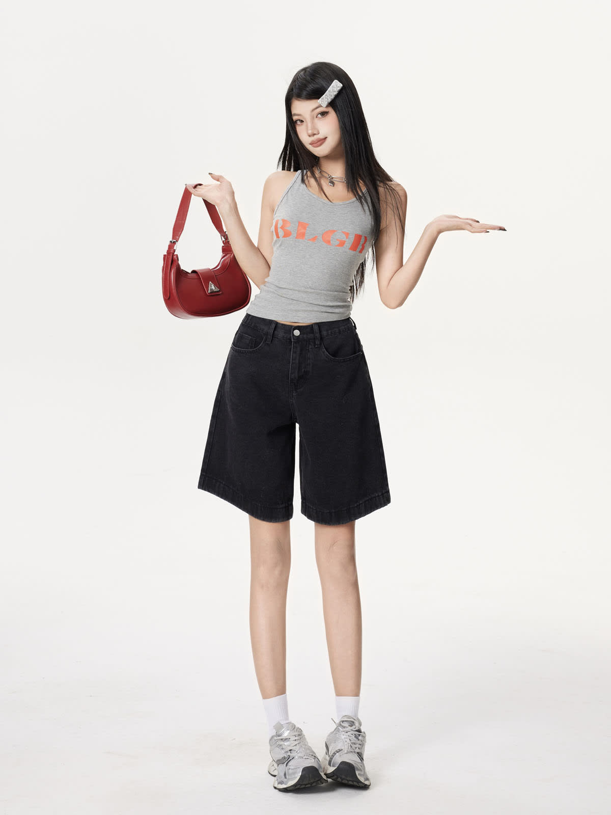YEEYEEWang Denim Bermuda Shorts in Solid Black, Asian-fit cut, full-body front standing pose, holding a red shoulder bag, other hand extended.