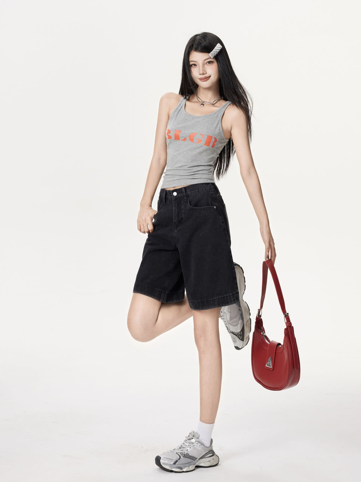 YEEYEEWang Denim Bermuda Shorts in Solid Black, Asian-fit cut, full-body leg-kick pose, holding a red shoulder bag in one hand.