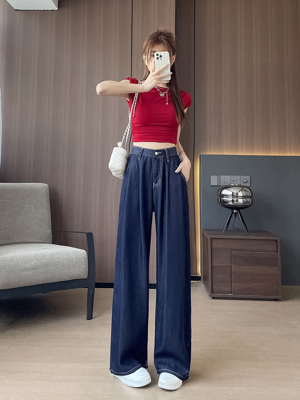 YEEYEEWang Wide-Leg Jeans in Denim Blue, Asian-fit cut, full-body front pose holding phone at face, one hand in pocket, white quilted chain bag on shoulder.