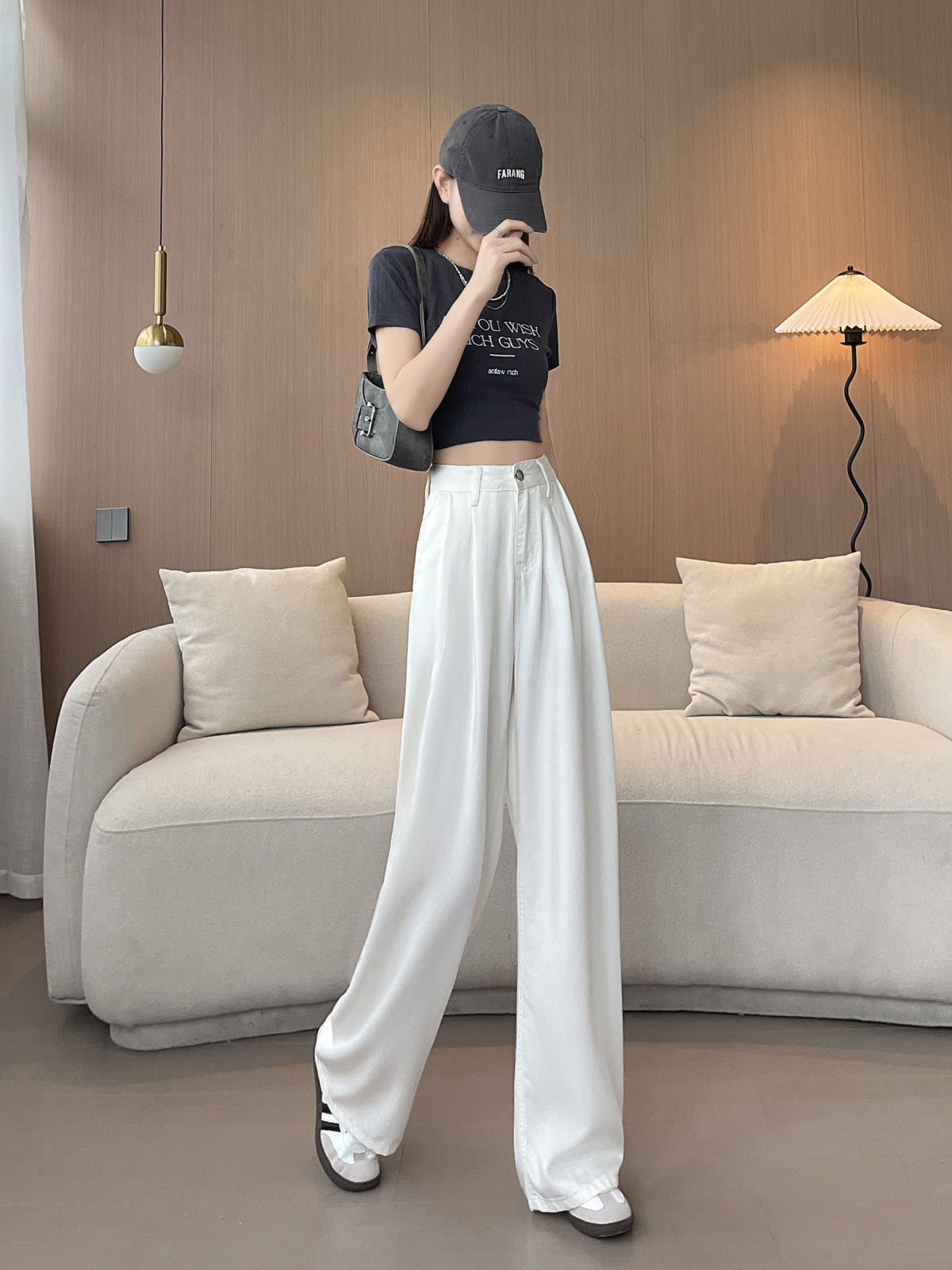 YEEYEEWang Wide-Leg Jeans in White, Asian-fit cut, full-body walking pose with legs crossed mid-step, one hand raised near face, gray shoulder bag.