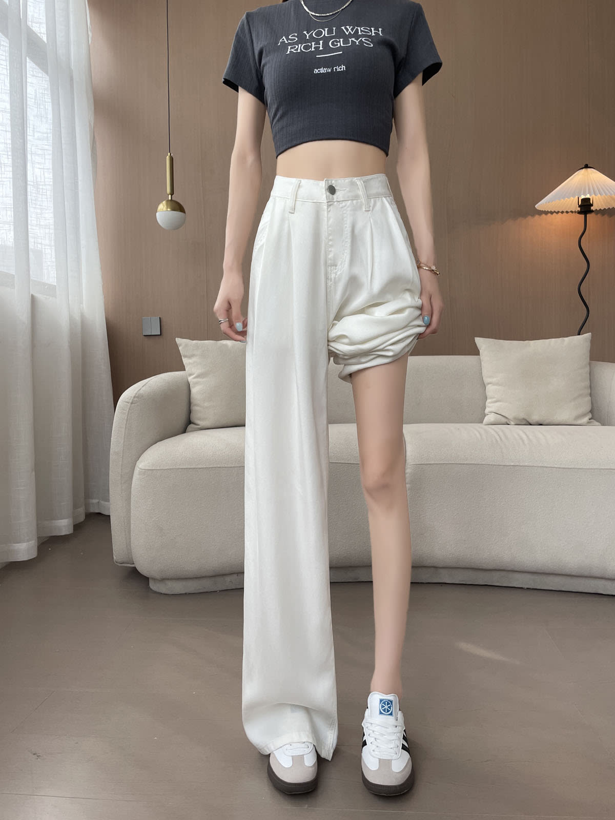 YEEYEEWang Wide-Leg Jeans in White, Asian-fit cut, waist-down view of model standing with one pant leg rolled up to show floor-sweeping drape and relaxed wide-leg silhouette.
