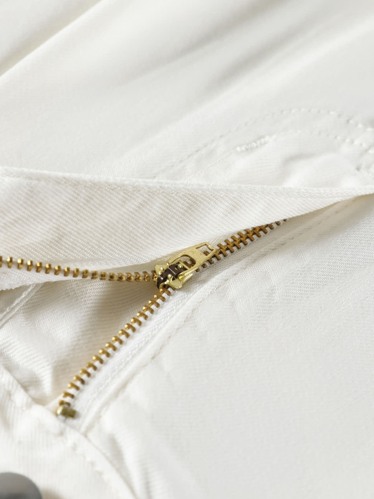 YEEYEEWang Wide-Leg Jeans in White, Asian-fit cut, close-up of antique bronze zipper with smooth metal teeth on white denim fly.