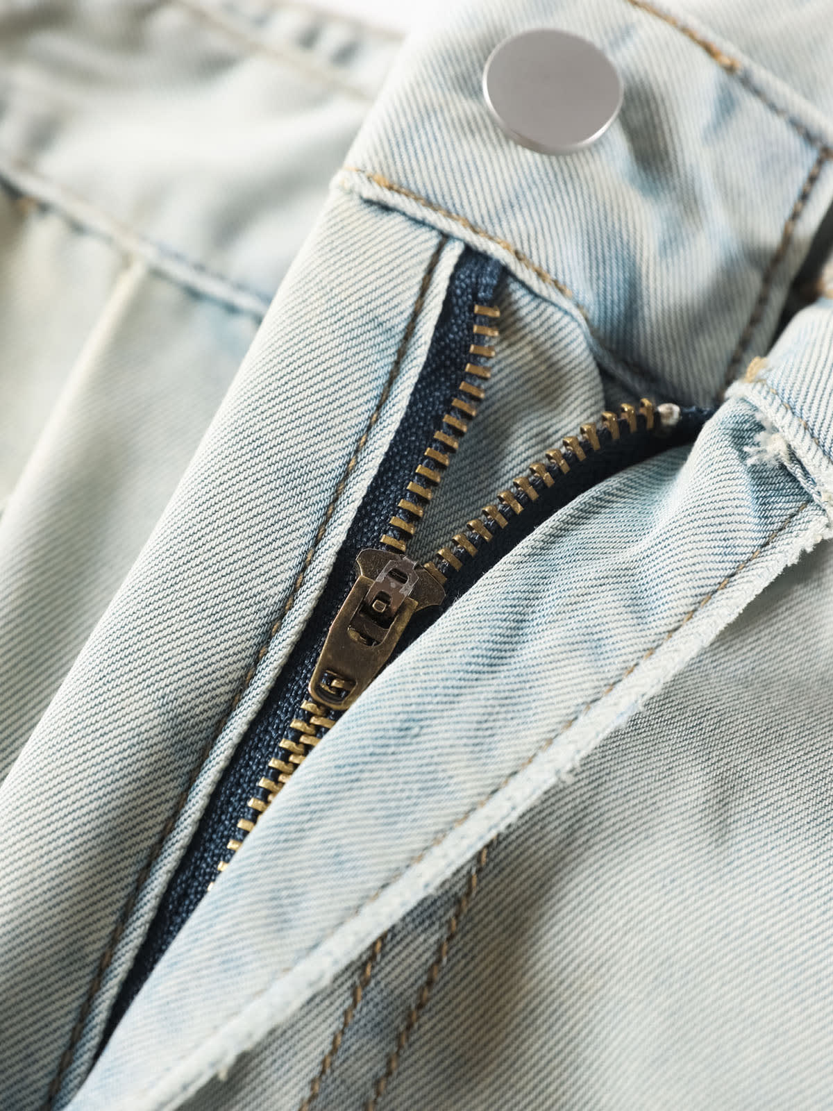 YEEYEEWang Wide-Leg Jeans in Light Blue, Asian-fit cut, close-up of antique bronze zipper and silver-tone button on light wash denim fly.