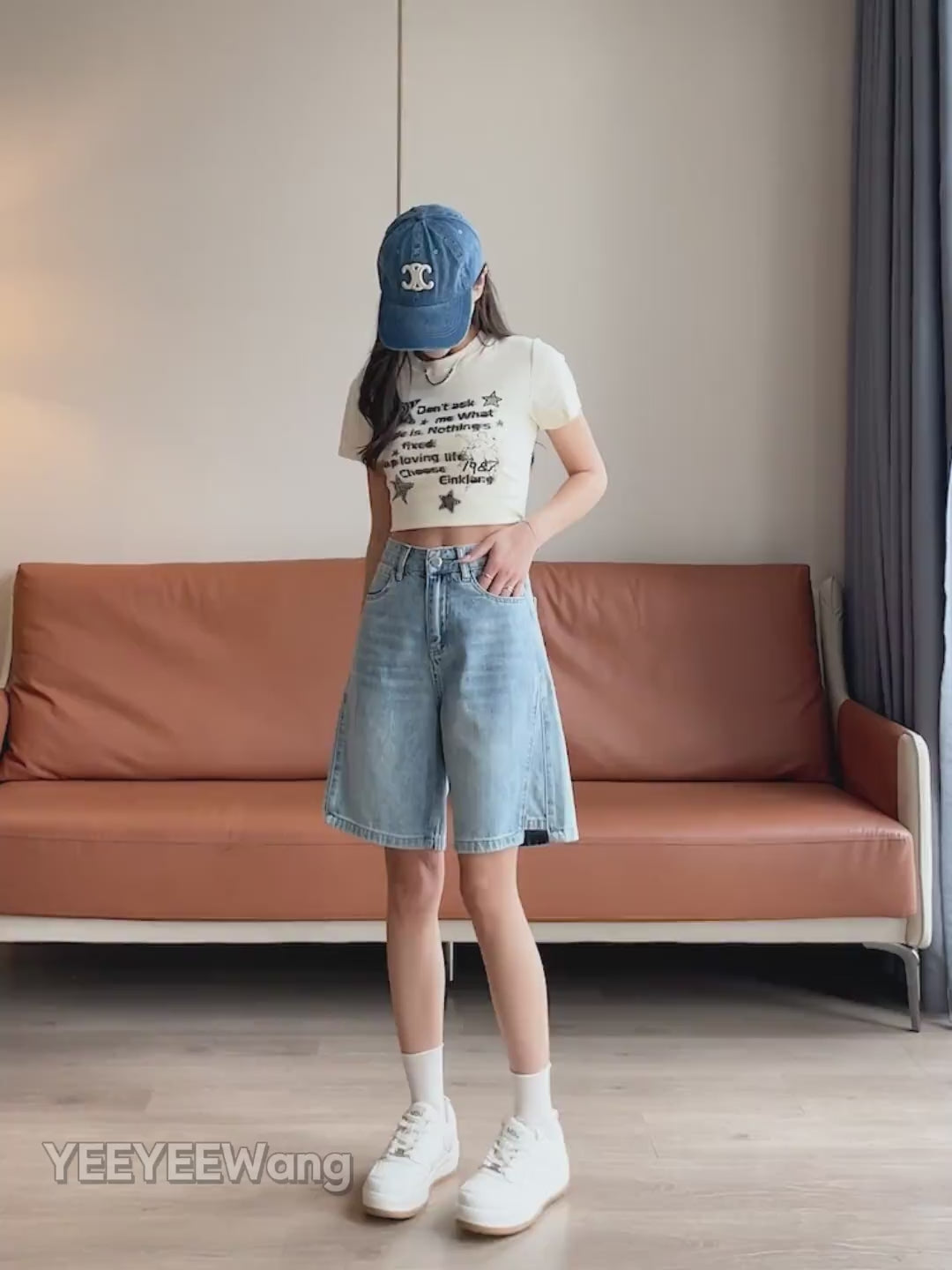 YEEYEEWang Denim Bermuda Shorts video in Blue: Asian model walks, lifts legs and turns to show high-waist wide-leg drape, frayed hems, daisy-embroidered back pockets in a cozy living room.