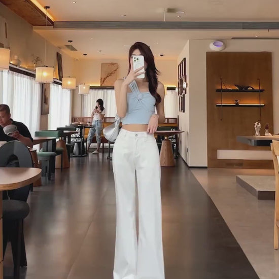 YEEYEEWang Flare jeans video: Asian model in White high-waist wide-leg denim turns and walks in a cafe, camera zooms in on draping hem and stacked cuffs.